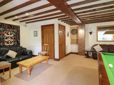 a living room with a couch and a pool table at Pengwern in Pennant-Melangell