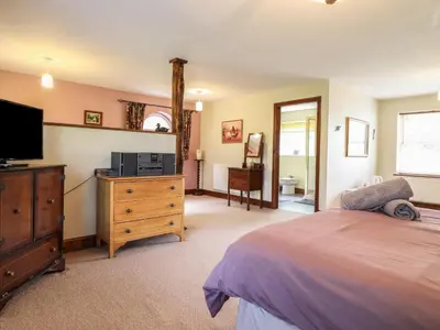 a bedroom with a bed and a flat screen tv at Pengwern in Pennant-Melangell