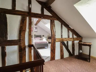 an attic room with a staircase and a bedroom at Pengwern in Pennant-Melangell