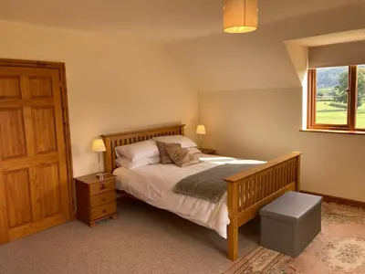 a bedroom with a large bed and a window at Pentrego Isaf in Meifod