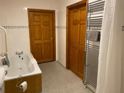 a bathroom with a tub and a sink and a shower at Pentrego Isaf in Meifod