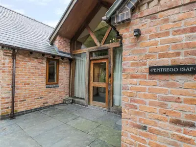 an entrance to a brick building with a door at Pentrego Isaf in Meifod