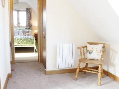 a chair with a pillow on it in a hallway at Acorn Cottage in Ludlow