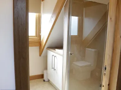 a bathroom with a toilet and a staircase at Acorn Cottage in Ludlow
