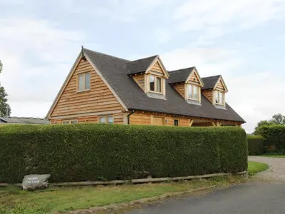 a wooden house with a roof on top of a hedge at Acorn Cottage in Ludlow