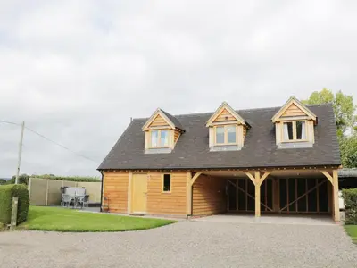 a house with a gambrel roof and a garage at Acorn Cottage in Ludlow