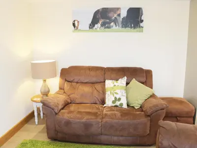 a brown leather couch sitting in a living room at Acorn Cottage in Ludlow