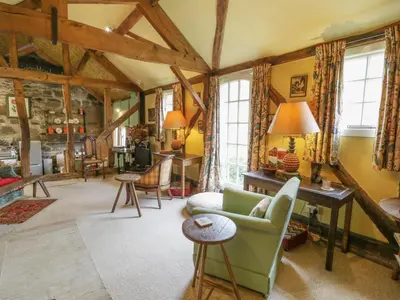 a living room with a couch and a table at Dolgenau Hir - The Barn in Trefeglwys