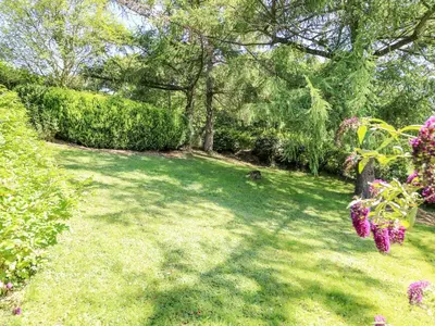 a yard with green grass and trees and flowers at Dolgenau Hir - The Barn in Trefeglwys