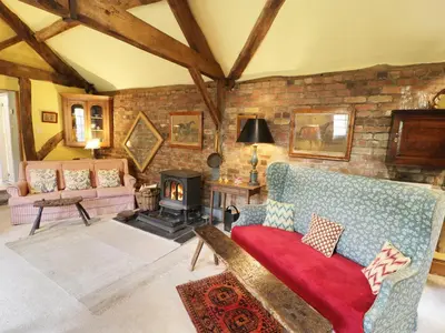 a living room with a couch and a fireplace at Dolgenau Hir - The Barn in Trefeglwys