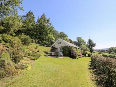 a house on a hill with a yard at Dolgenau Hir - The Barn in Trefeglwys