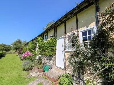 a house with a white door and some plants at Dolgenau Hir - The Barn in Trefeglwys