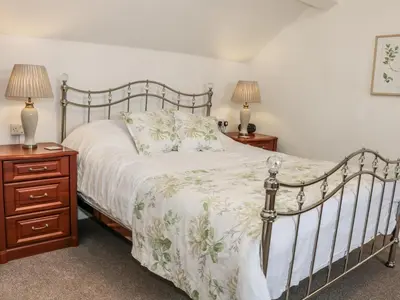 a bedroom with a bed and two night stands and two lamps at The Hayloft in Shelve
