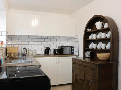 a kitchen with white cabinets and a sink at The Hayloft in Shelve