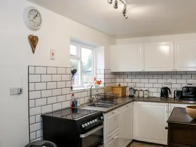 a kitchen with white cabinets and a black stove top oven at The Hayloft in Shelve