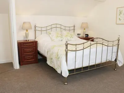 a bedroom with a bed and two night stands with lamps at The Hayloft in Shelve