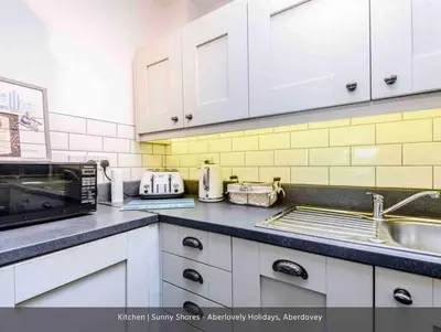 a kitchen with a sink and a microwave at Sunny Shores in Aberdyfi