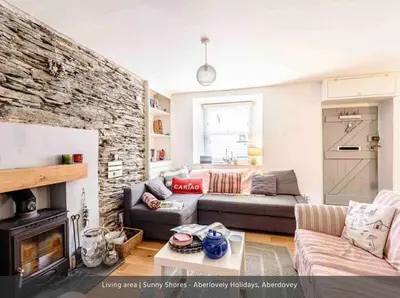 a living room with a couch and a fireplace at Sunny Shores in Aberdyfi
