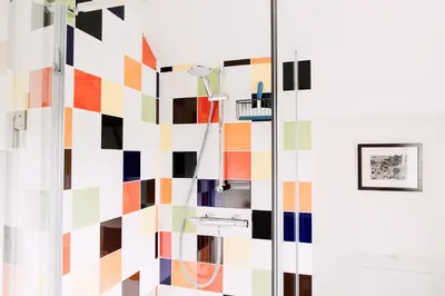 a bathroom with a colorful geometric wall at The Barn at Ty Beic in Bala