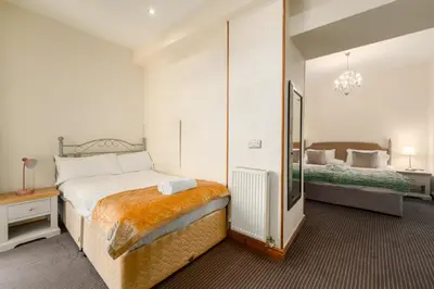 a bedroom with a large bed and a mirror at Gwesty'r Marine Hotel & Spa in Aberystwyth