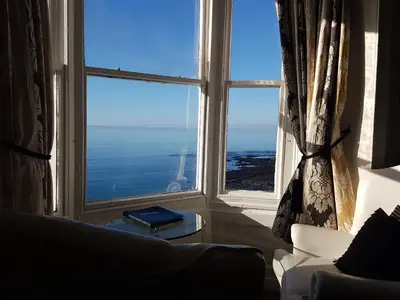 a living room with a view of the ocean from a window at Gwesty'r Marine Hotel & Spa in Aberystwyth