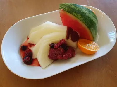 a plate of food with fruit on a table at Gwesty'r Marine Hotel & Spa in Aberystwyth