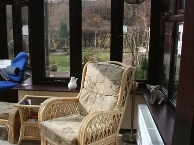 a cat sitting in a chair in front of a window at The Old School House in Llanbrynmair