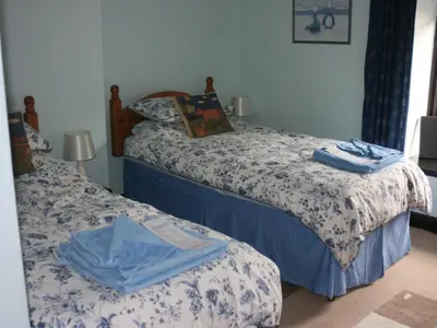 a bedroom with two beds with blue and white sheets at The Old School House in Llanbrynmair
