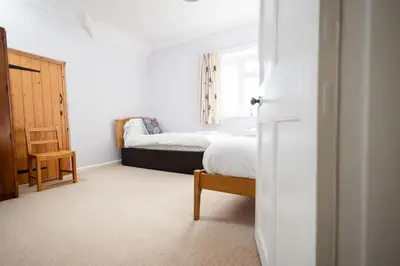 a bedroom with a bed and a chair and a window at Oak House in Mid Wales with Log Burner By Seren Short Stays in Machynlleth