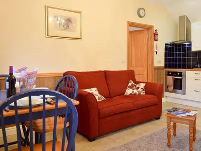 a living room with a red couch and a table at Ty Bach Twt in Llangeitho