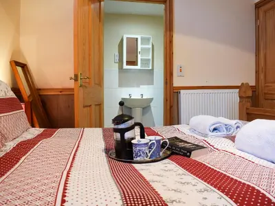 a bed with a tray with a coffee maker on it at Ty Bach Twt in Llangeitho
