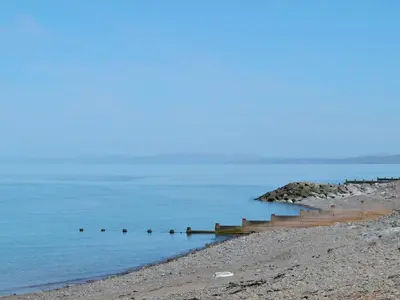 a beach with a pier in the water at Ty Bach Twt in Llangeitho
