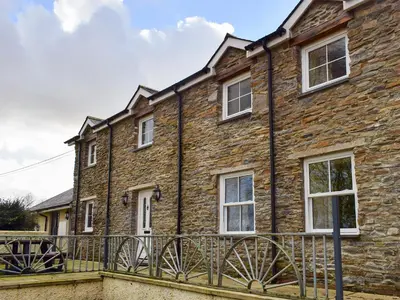 a stone house with a fence in front of it at Penrhiw in Llangeitho