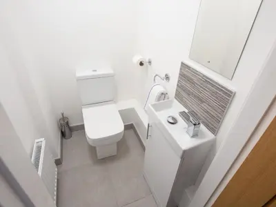 a white bathroom with a toilet and a sink at Minafon in Llangollen