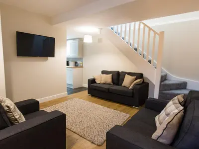 a living room with two couches and a tv at Hafan in Llangollen