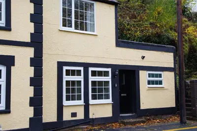a house with a black door and white windows at Catref in Llangollen