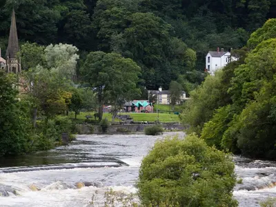a river with a town in the background at Catref in Llangollen