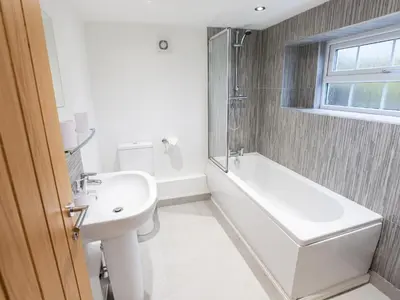 a bathroom with a sink and a tub and a toilet at Catref in Llangollen