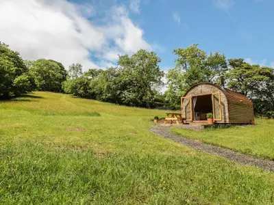 a wooden shed in a field with a path at Dingle Den in Hereford