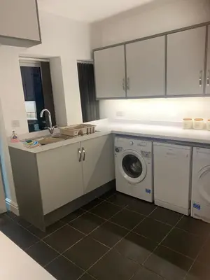 a kitchen with a sink and a washing machine at Heulwen in Barmouth
