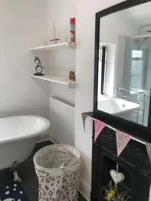 a bathroom with a mirror and a sink and a tub at Heulwen in Barmouth