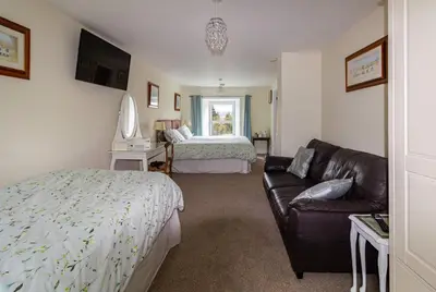 a living room with a couch and a bed at Maes y Gwaelod in Llanwrtyd Wells