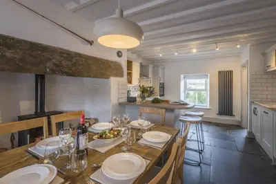 a kitchen and dining room with a table and chairs at Finest Retreats - Tegannedd - Luxury Grade II Listed Cottage With Hot Tub in Ffestiniog