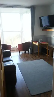 a living room with a couch and a large window at Apartment Chic in Barmouth