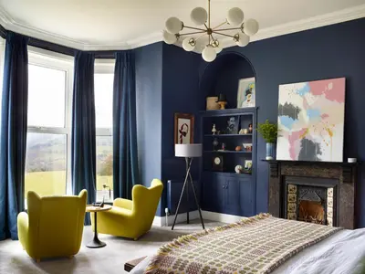 a bedroom with blue walls and a bed and chairs at The Royston in Llanbrynmair