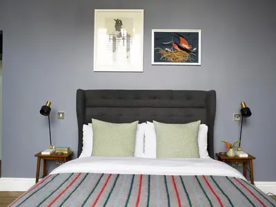 a bedroom with a bed with two pictures on the wall at The Royston in Llanbrynmair
