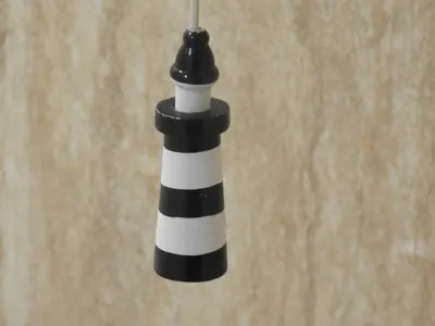 a black and white lighthouse candle hanging from a wall at Hawen - Barmouth in Barmouth