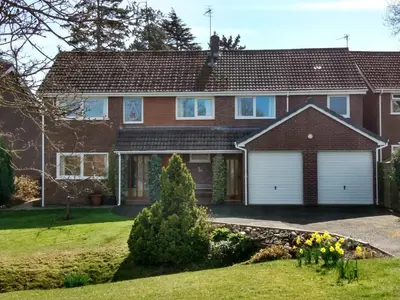 a house with white garage doors in a yard at Nant Gloyw Oswestry in Oswestry