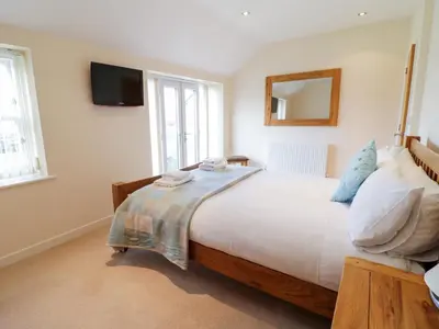 a bedroom with a large bed and a mirror at Tyn Y Buarth in Dyffryn
