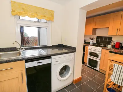a kitchen with a washing machine and a sink at Edrydd in Harlech